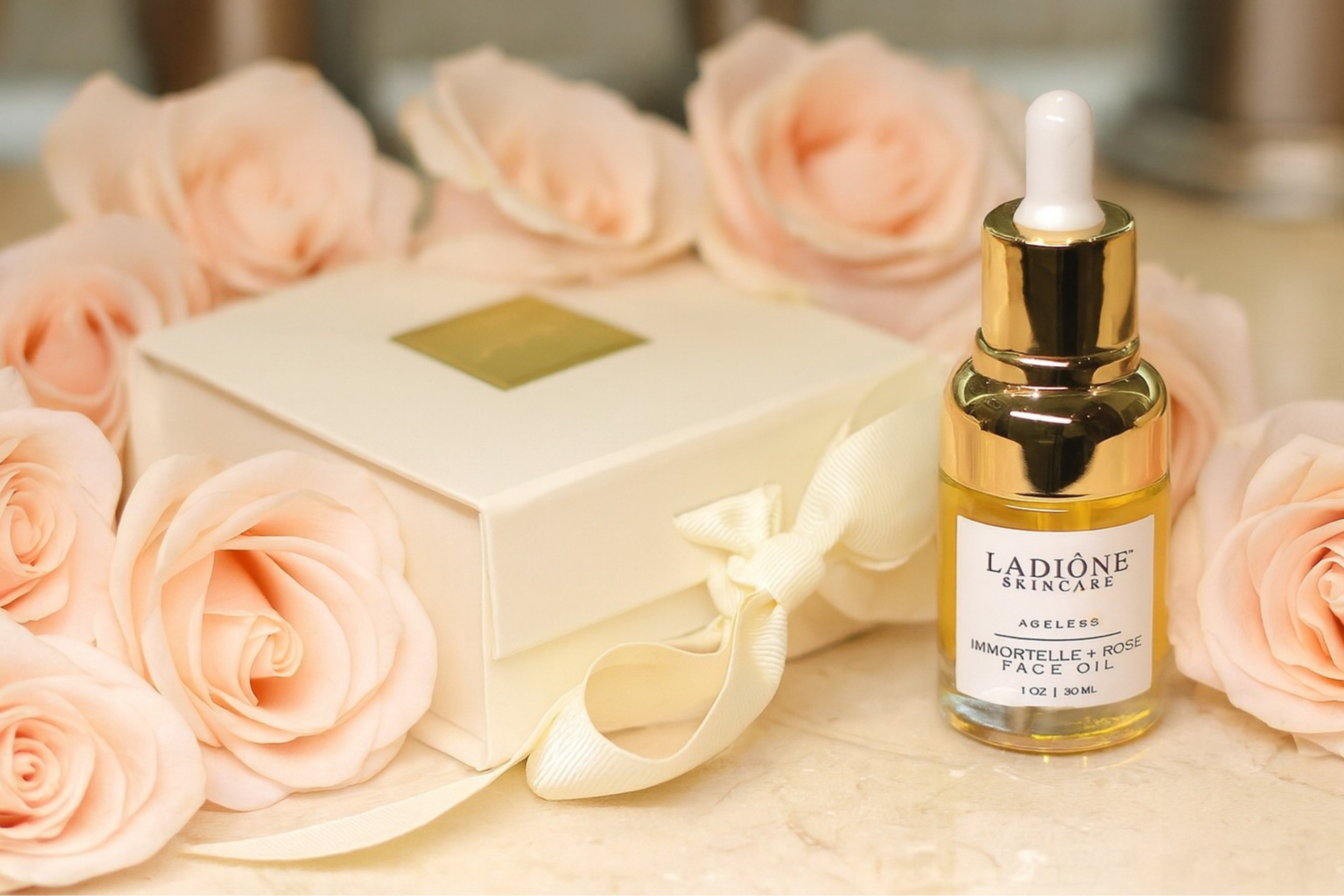 Ladione skincare serum bottle with a box and pink roses on a wooden surface