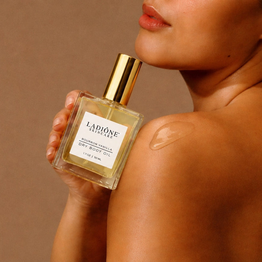 Woman holding a perfume bottle with a brown background
