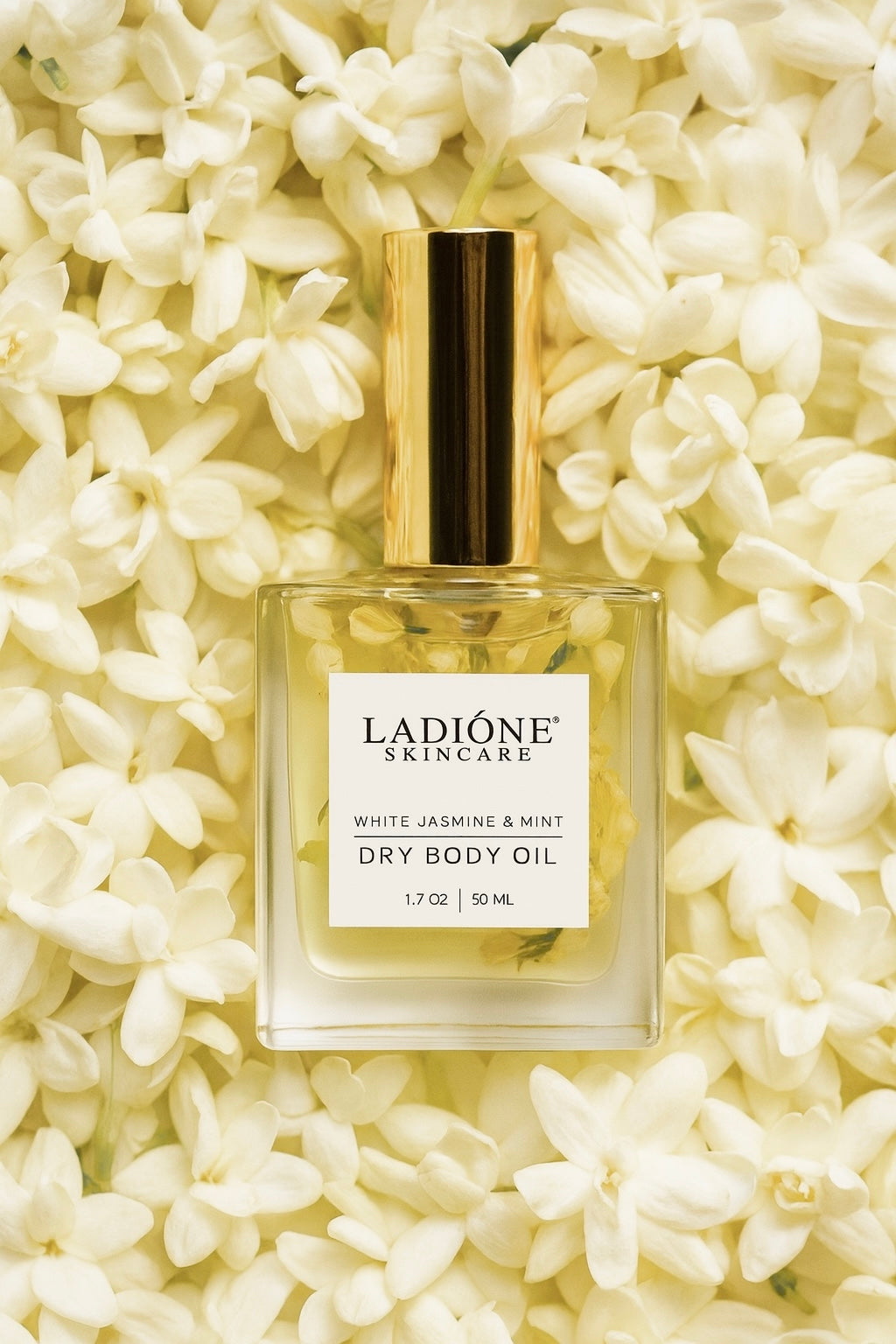 Ladione Skincare dry body oil bottle on a bed of white flowers